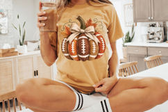 Hand-painted football pumpkin clipart with orange and brown football sections, cream stripes, fall leaves, curly vines, and a textured farmhouse bow.