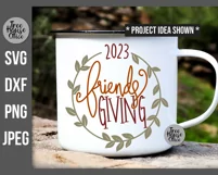 Friendsgiving 2023 with wreath SVG shown on a white camping mug as a project idea.  Thanksgiving with friends SVG, DXF, PNG, and JPEG file types included.