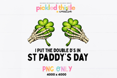 White St Paddys Day shirt featuring skeleton hands holding green shamrocks above the phrase “I Put The Double D’s In St Paddy’s Day” in bold black lettering.