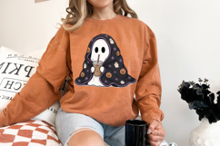 PNG only design featuring a blanket-wrapped ghost with coffee, pumpkins, stars, and little ghost accents in a playful Halloween style.