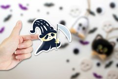 hand holding a Halloween sticker of a death character 