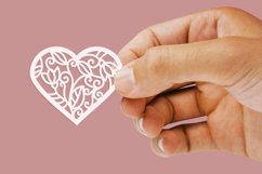 hand holding papercut heart 