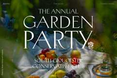 Poster for "The Annual Garden Party" featuring elegant white serif typography over a soft-focus picnic scene with fruits. The design conveys a sophisticated, classic outdoor event atmosphere.