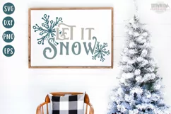 Let it Snow text with blue hand-drawn snowflake shown on a white sign with a wooden frame