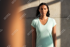 Woman wearing light blue t shirt against concrete wall Product Image 1