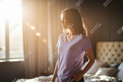 Woman wearing lavender t-shirt in sunlit bedroom Product Image 1
