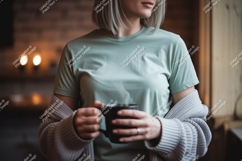 Woman wearing light green t shirt holding black mug Product Image 1