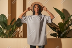 Woman wearing grey t-shirt and hat plants Product Image 1