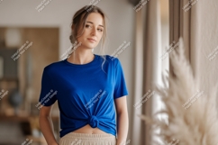 Woman wearing blue t-shirt and beige pants Product Image 1