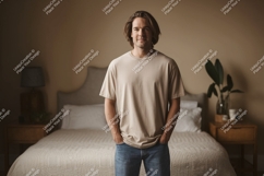 Man wearing beige t-shirt and jeans in bedroom casual Product Image 1