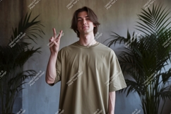Man wearing olive green t-shirt making peace sign image Product Image 1