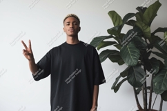 Young man black t shirt peace sign plant Product Image 1