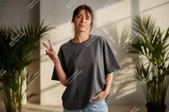 Woman wearing dark grey t-shirt and blue jeans image Product Image 1