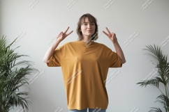 Woman wearing mustard t shirt peace sign image Product Image 1