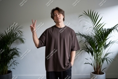 Young man showing peace sign with plants Product Image 1
