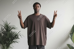 Man wearing brown t shirt making peace sign image Product Image 1