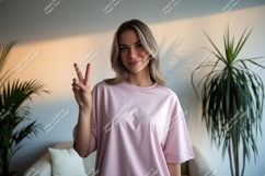 Woman wearing pink t-shirt showing peace sign image Product Image 1