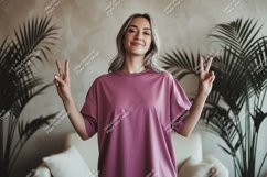 Woman wearing pink t shirt making peace sign image Product Image 1