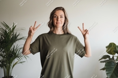 Woman wearing olive green t-shirt making peace sign Product Image 1