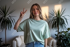 Woman wearing light green t-shirt showing peace sign Product Image 1