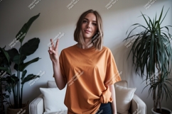 Woman orange shirt peace sign indoor image Product Image 1