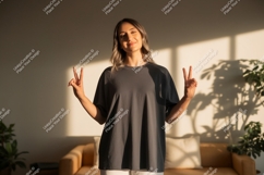 Woman wearing grey t-shirt making peace sign image Product Image 1