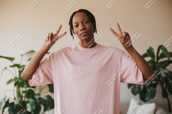 Person wearing pink t-shirt making peace sign image Product Image 1