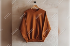 Orange Sweatshirt Hanging On Wooden Wall Tshirt Mockup Product Image 1