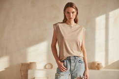Woman wearing beige top and ripped jeans image Product Image 1