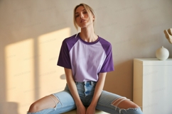 Woman wearing purple and lilac raglan t shirt ripped jeans Product Image 1