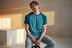 Young man wearing teal raglan t shirt ripped jeans Product Image 1