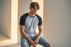 Young man wearing grey and black raglan shirt Product Image 1