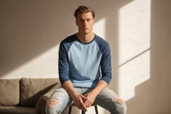 Man wearing blue raglan shirt and ripped jeans light Product Image 1