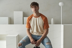 Young man wearing raglan t shirt and ripped jeans Product Image 1