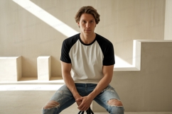 Young man wearing baseball shirt and ripped jeans image Product Image 1