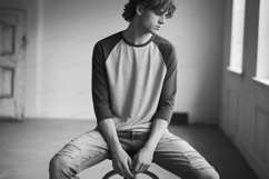 Young man wearing baseball shirt and ripped jeans Product Image 1