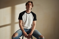 Young man wearing baseball shirt and ripped jeans Product Image 1