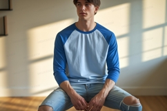 Young man wearing blue raglan shirt and ripped jeans Product Image 1