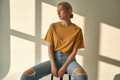 Woman wearing mustard t shirt ripped jeans image Product Image 1
