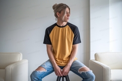Man wearing yellow and black raglan shirt and ripped jeans Product Image 1