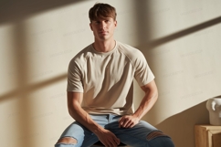 Young man wearing beige t shirt and ripped jeans image Product Image 1