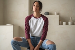 Woman wearing maroon and white baseball shirt ripped jeans Product Image 1
