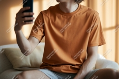 Orange shirt person holding phone image Product Image 1