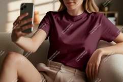 Woman wearing maroon t-shirt holding phone image Product Image 1