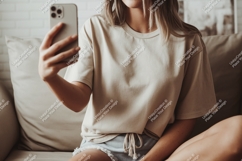 Woman holding phone taking selfie couch casual Product Image 1