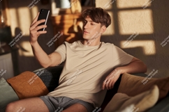 Man taking selfie on couch phone indoor Product Image 1