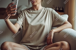 Woman holding phone taking selfie on couch indoor Product Image 1