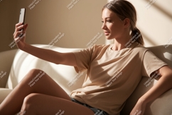 Woman taking selfie on couch phone indoor Product Image 1