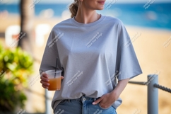 Woman wearing grey t shirt holding drink image Product Image 1