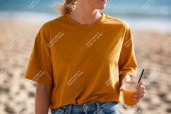 Woman wearing mustard t shirt holding orange drink Product Image 1